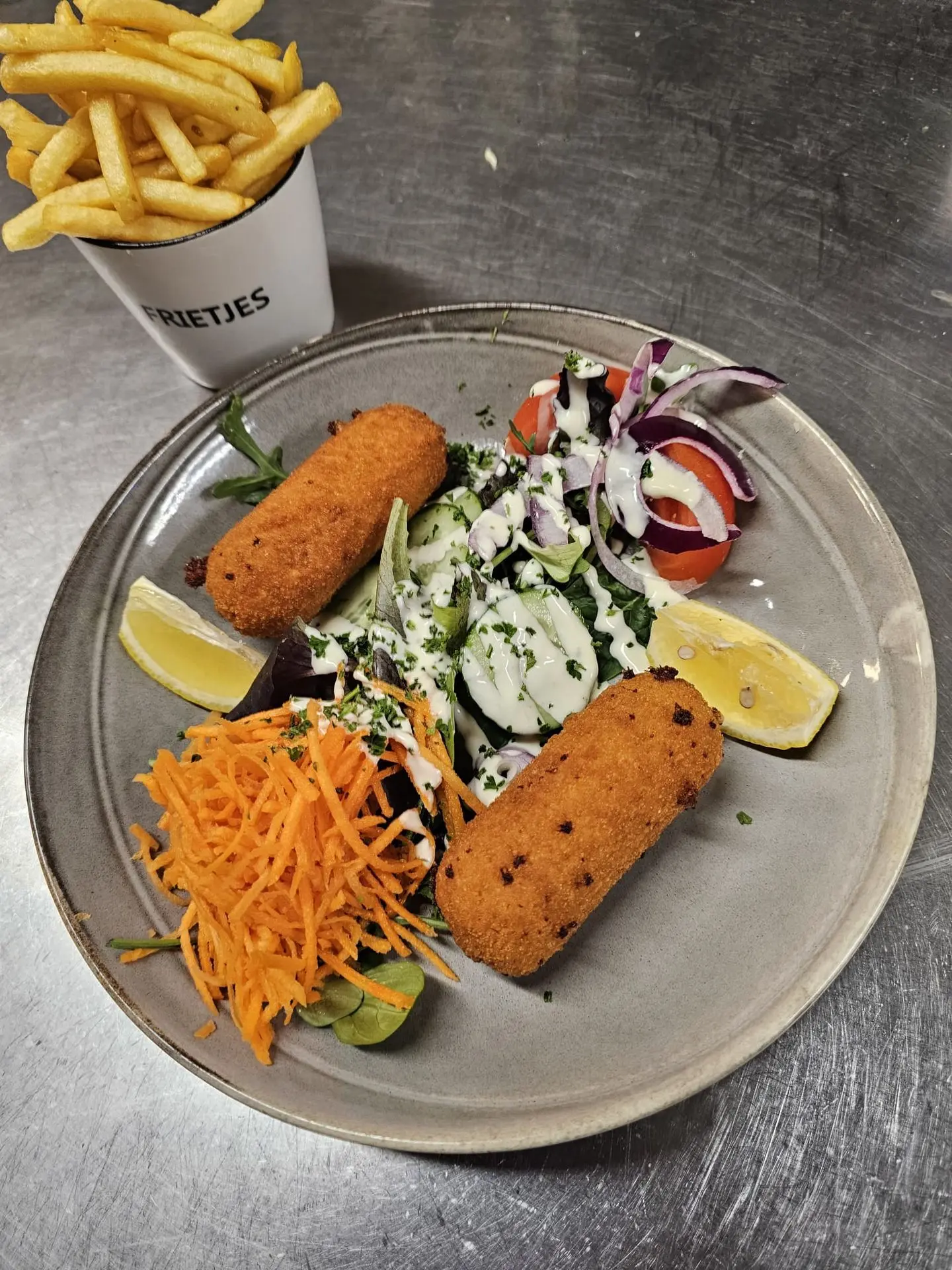 Bord met frietjes, kroketten en salade in San Marco